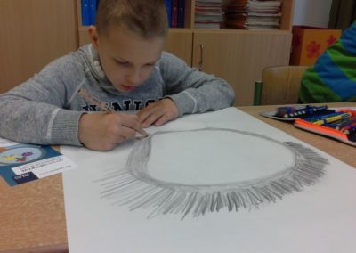 Luka zeichnet eine große Lupe auf seinen Kopf.